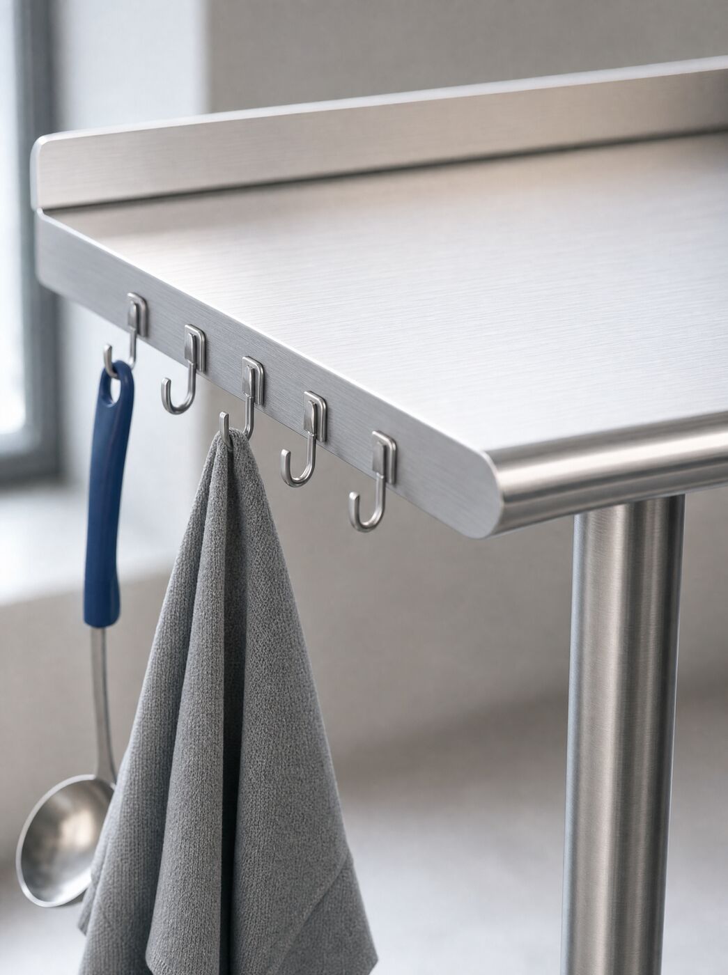 Close view of the rolled front edge and the five stainless hooks