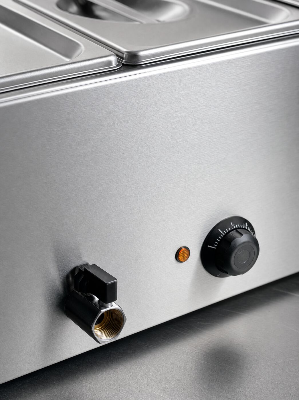 Close view of the thermostat dial, indicator light and drain tap