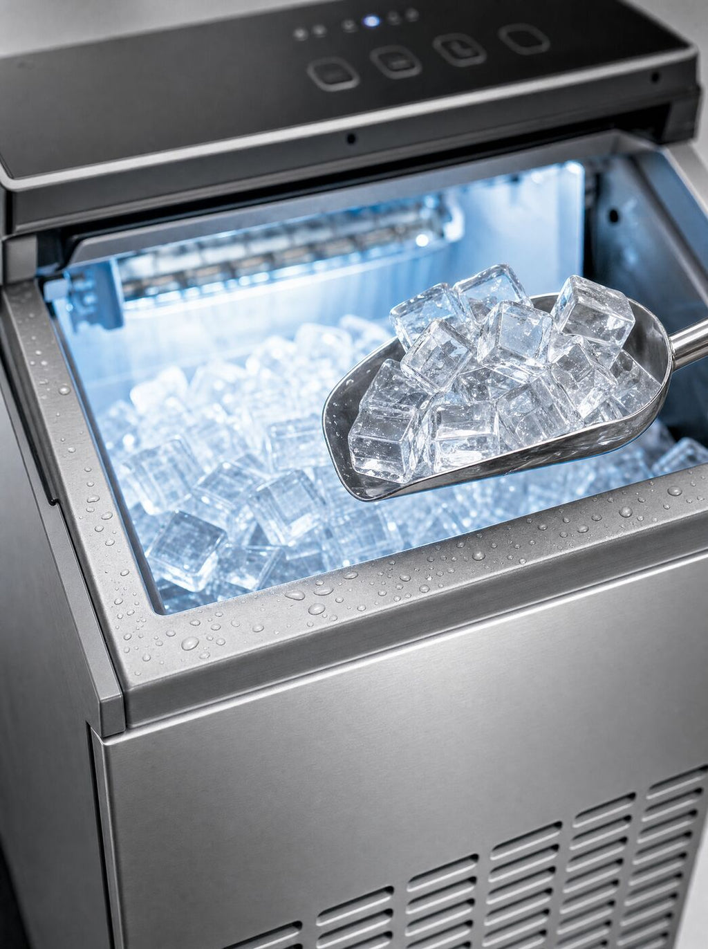 Close view of a scoop lifting clear cubes from the bin