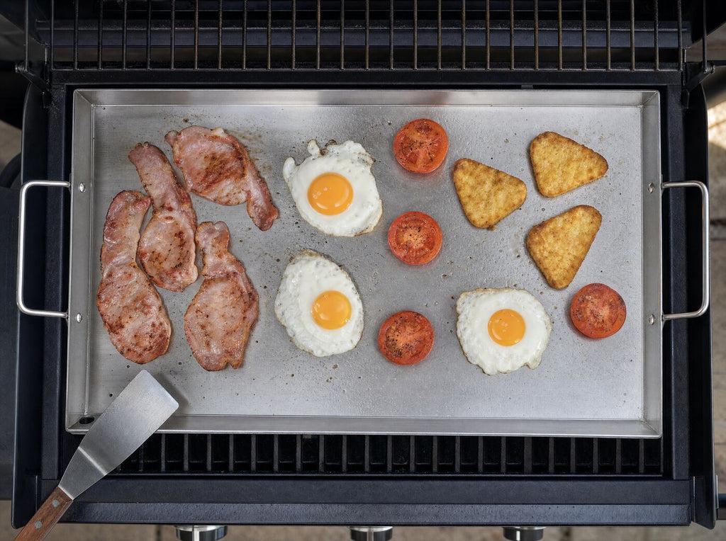 Looking down at breakfast cooking across the griddle plate