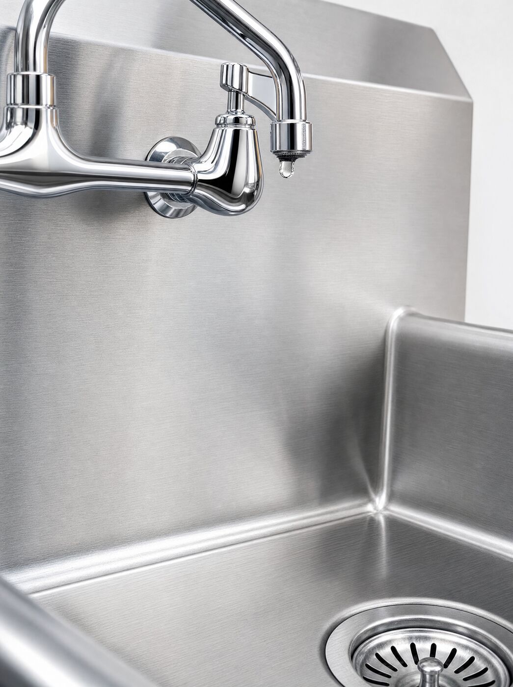 Close view of the welded rear corner of the bowl and the swivel tap